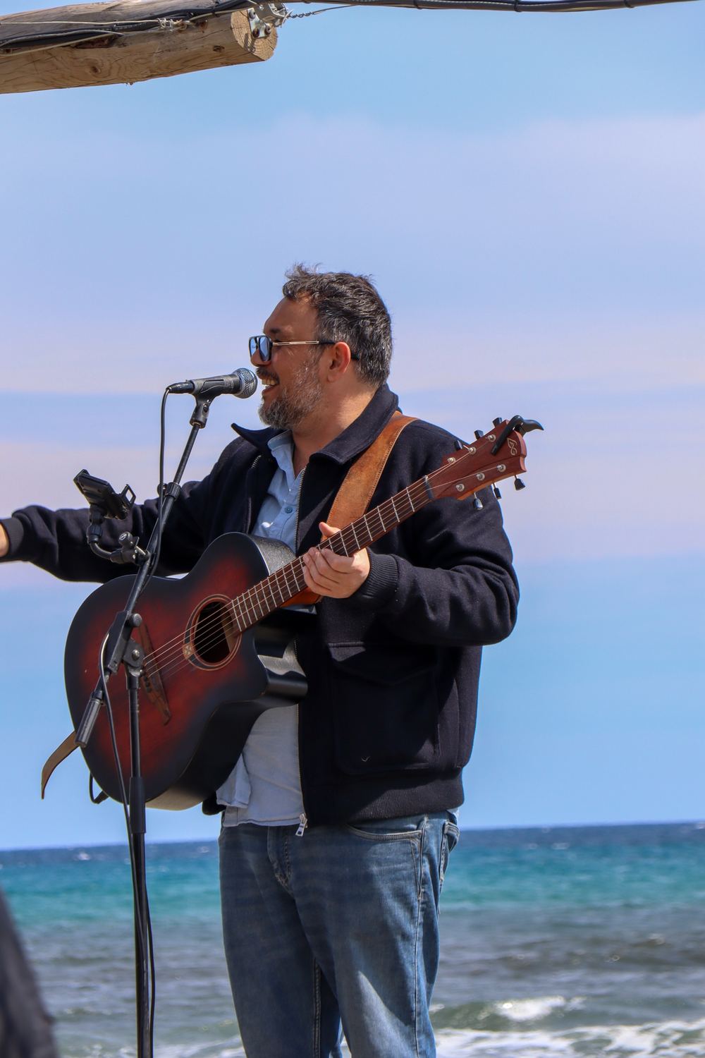 Guitariste chantant face à la mer