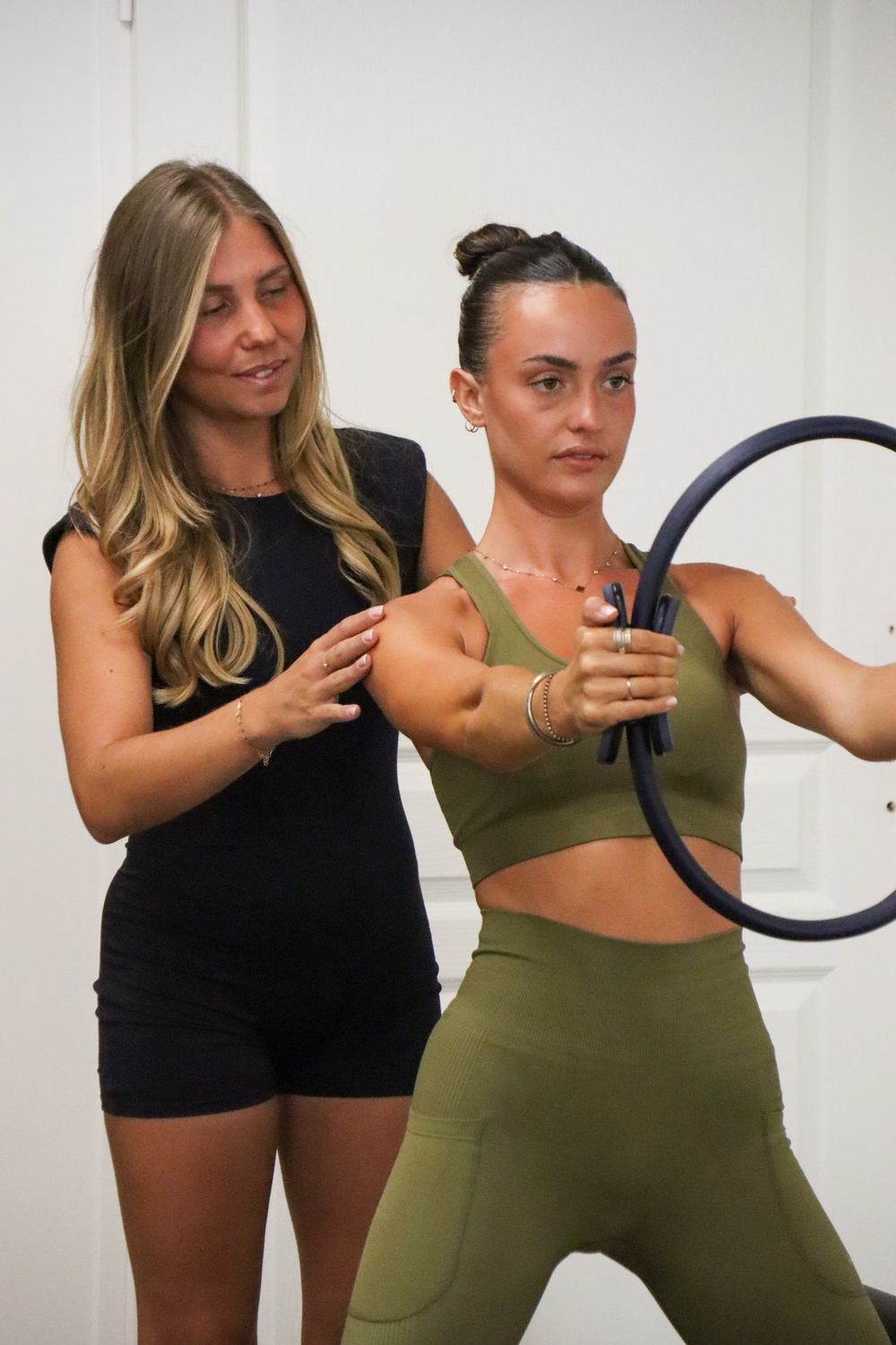 Coach de Pilates corrigeant la posture d’une élève