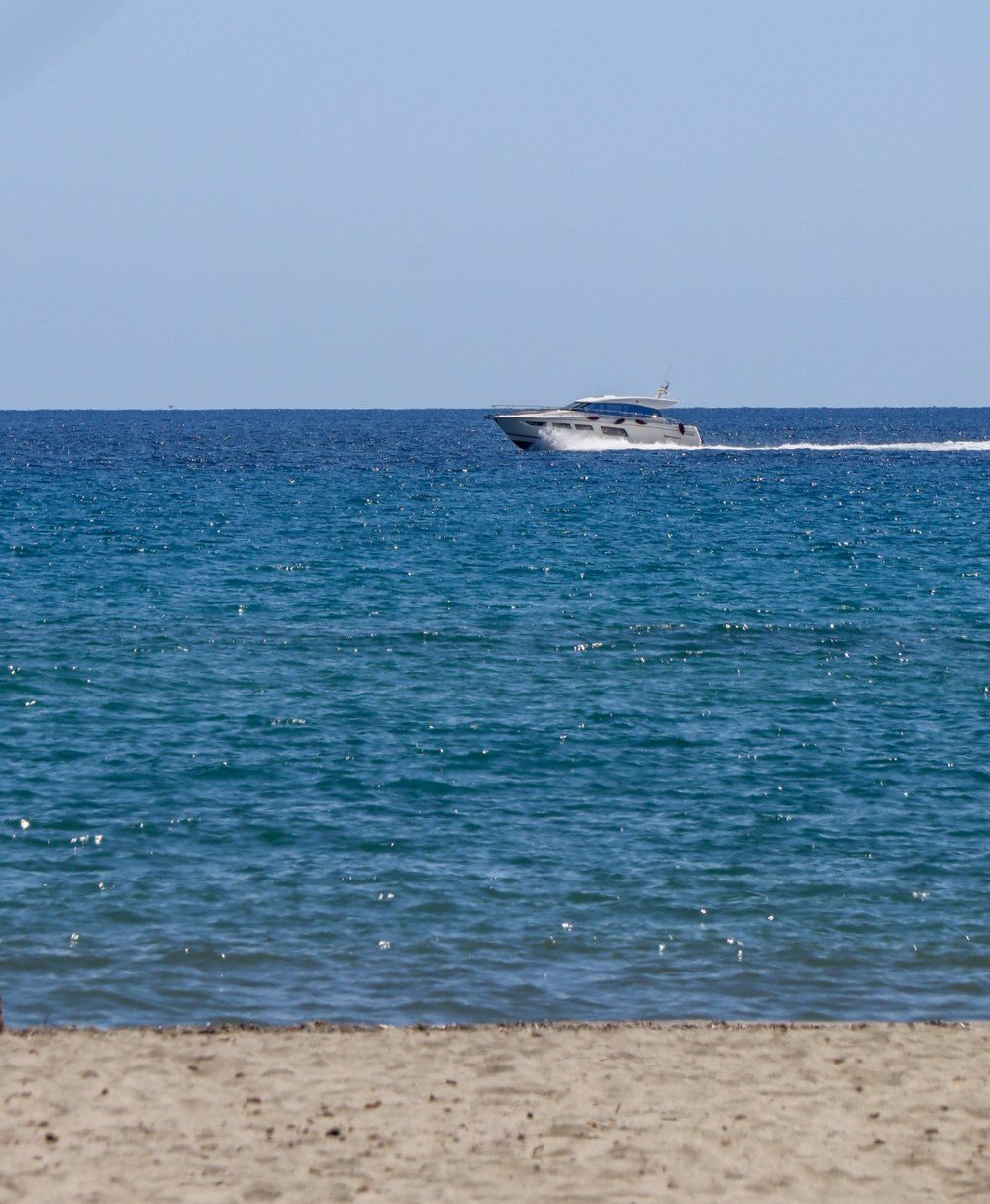 Plage de sable et mer turquoise, un bateau au large
